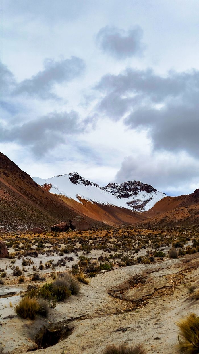 Scenic view of the Andes mountains with snowy peaks and a dramatic cloudy sky in Arequipa, Peru.