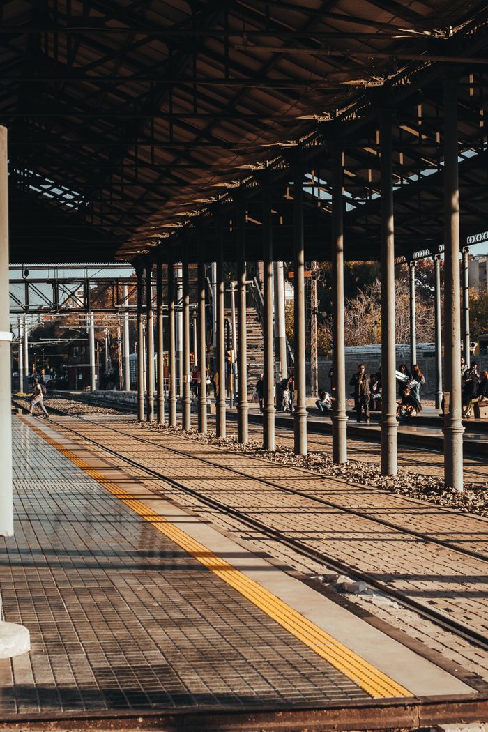 Sunlit view of a railway platform in Mendoza, Argentina, showcasing architectural symmetry.