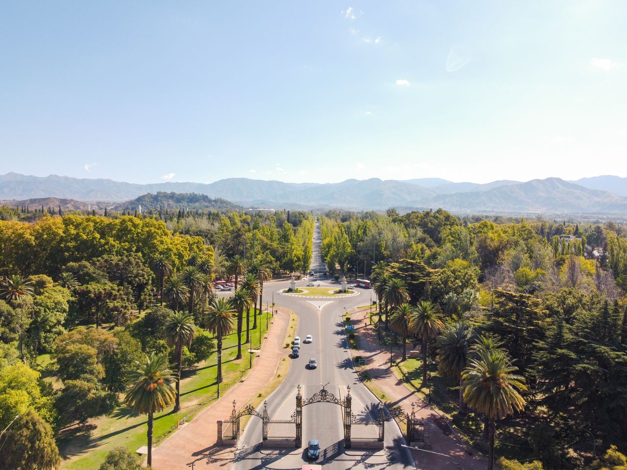 Services Captivating aerial view of a roadway surrounded by lush greenery and mountains in Mendoza, Argentina.